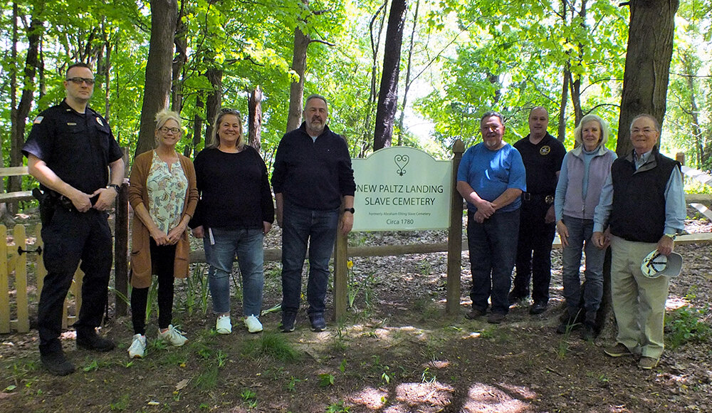 Last Monday a small group of town officials planted flowers at the newly restored New Paltz Slave Cemetery in the Town of Lloyd. Pictured L-R Lt. Phil Roloson, Town Clerk Wendy Rosinski, Ulster County Legislator Gina Hansut, Supervisor Dave Plavchak, Councilman John Fraino, Police Chief James Janso, Town Historian Joan Kelley and Councilman Mike Guerriero.